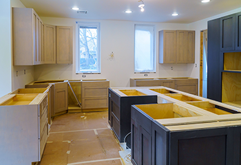 This image is relevant as it showcases the progress and quality of work involved in a kitchen remodeling project, highlighting the transformation from an unfinished space to a modern, functional kitchen.